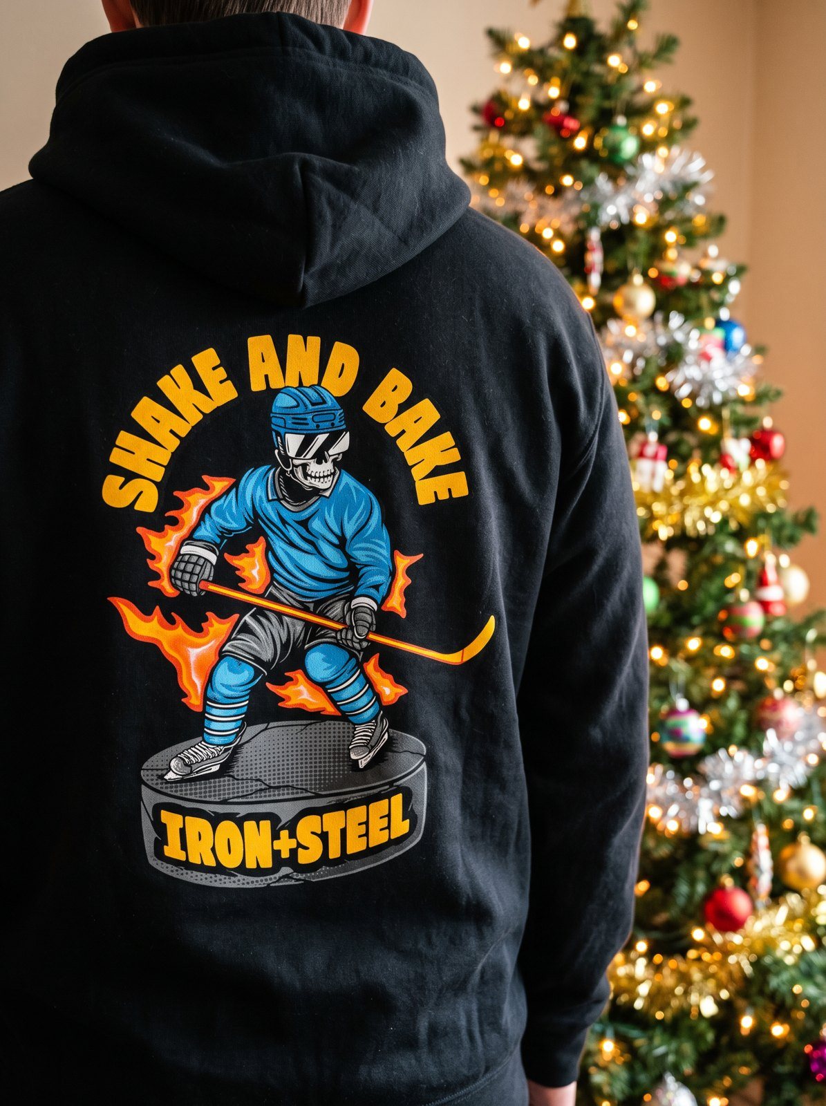 Shake and Bake hockey hoodie, back print, in front of a lit Christmas tree