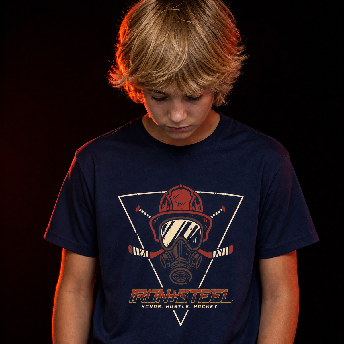 Firefighter Hustle Hockey Tee in navy worn by a young hockey player, front print with firefighter helmet, gas mask and crossed hockey sticks over the words Honor Hustle Hockey