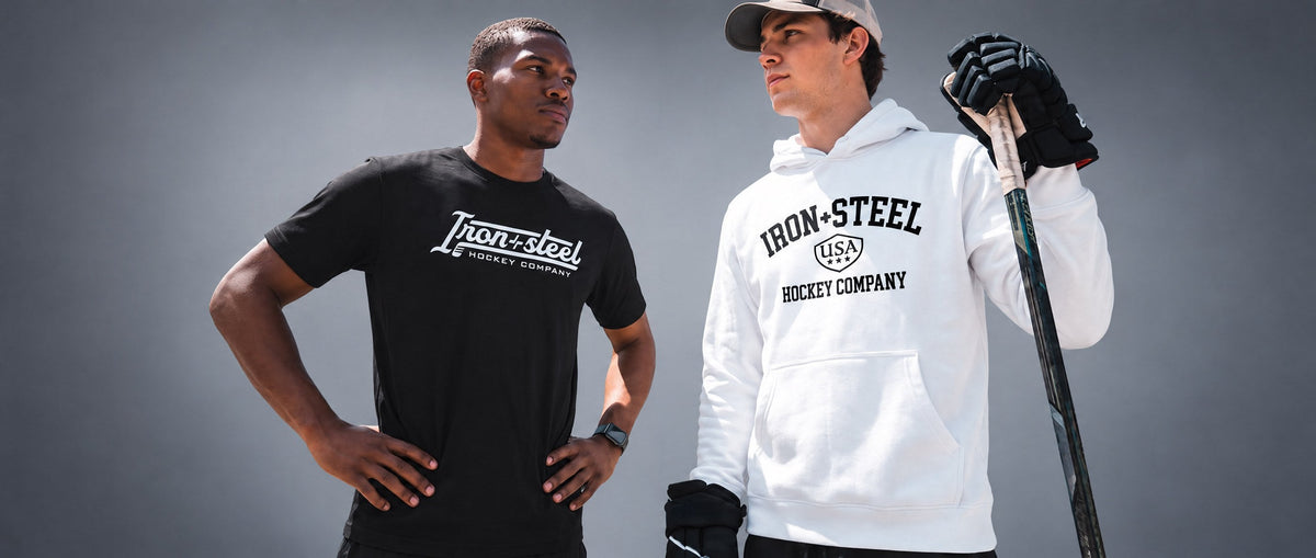 Two hockey players in Iron+Steel Hockey Company apparel, one holding a stick
